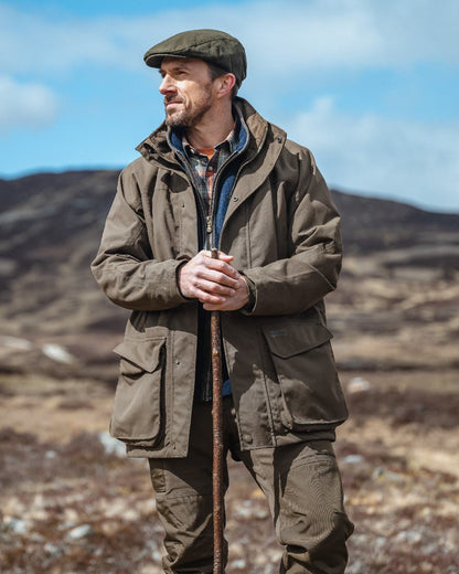 Green Coloured Hoggs of Fife Ballater Waterproof Field Trousers on blurry background 