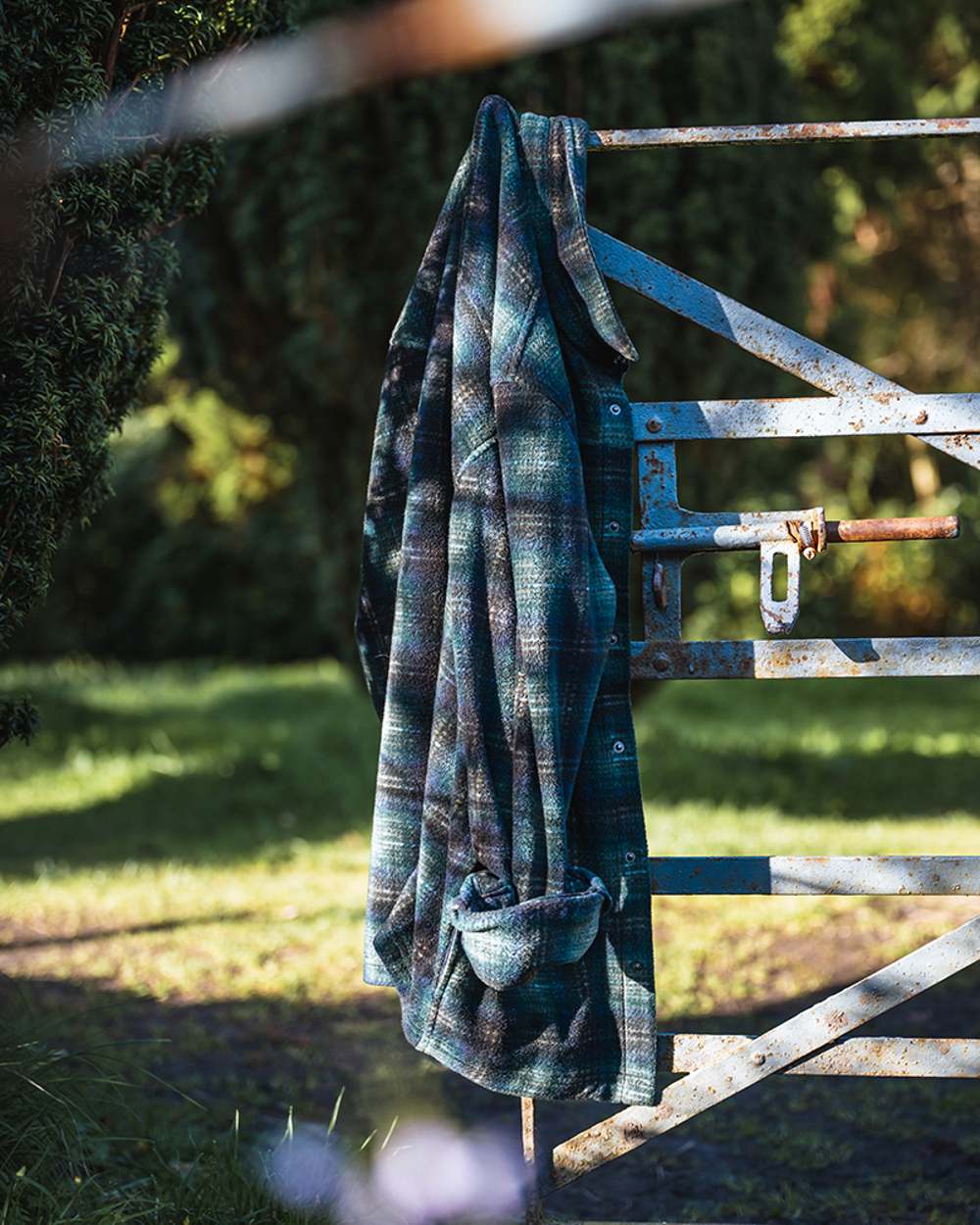 Navy Green Gold coloured Hoggs of Fife Broxburn Fleece Shacket on backyard background 