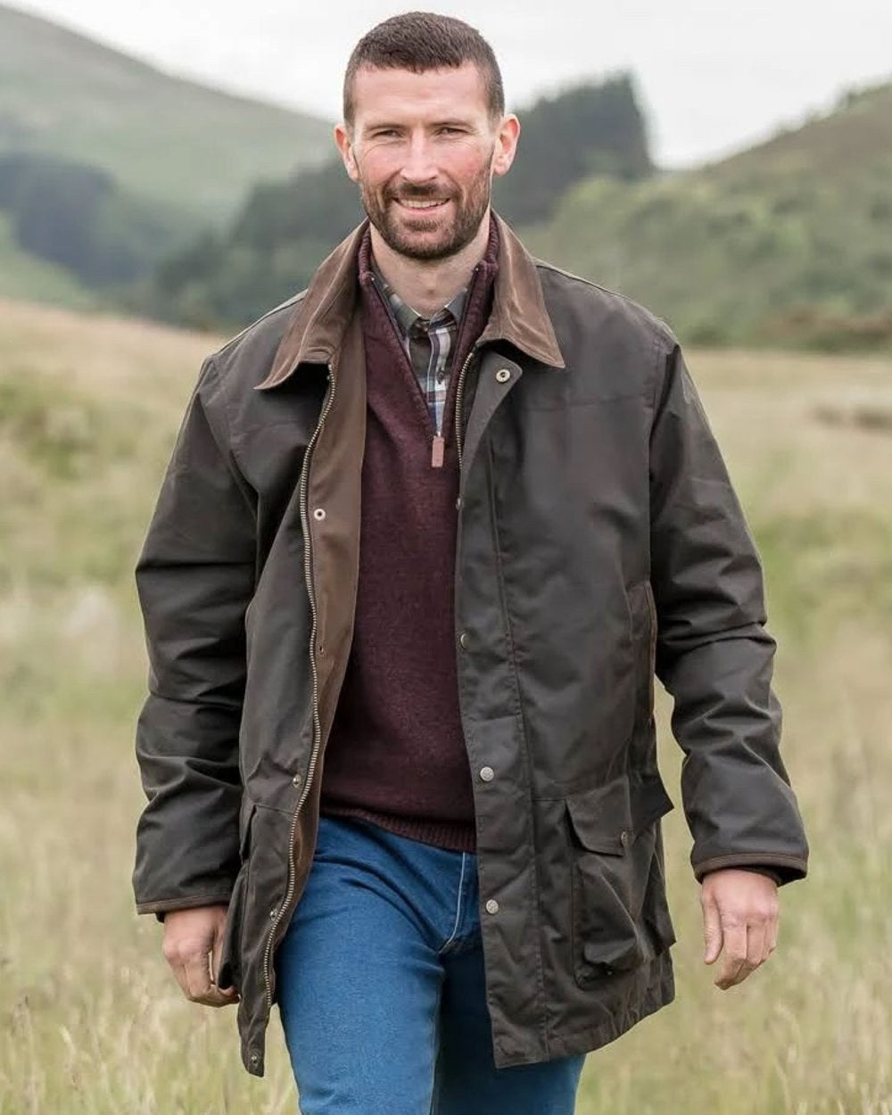 Olive Coloured Hoggs of Fife Caledonia Waxed Jacket on blurry background 