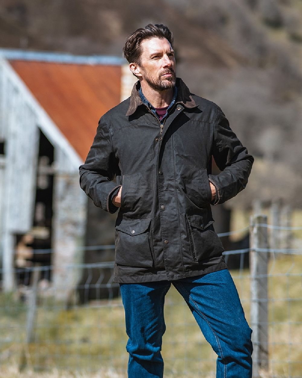 Olive Coloured Hoggs of Fife Caledonia Waxed Jacket on blurry background 