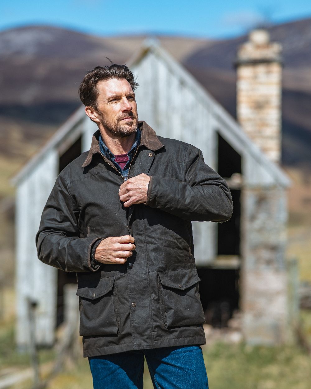 Olive Coloured Hoggs of Fife Caledonia Waxed Jacket on house background 