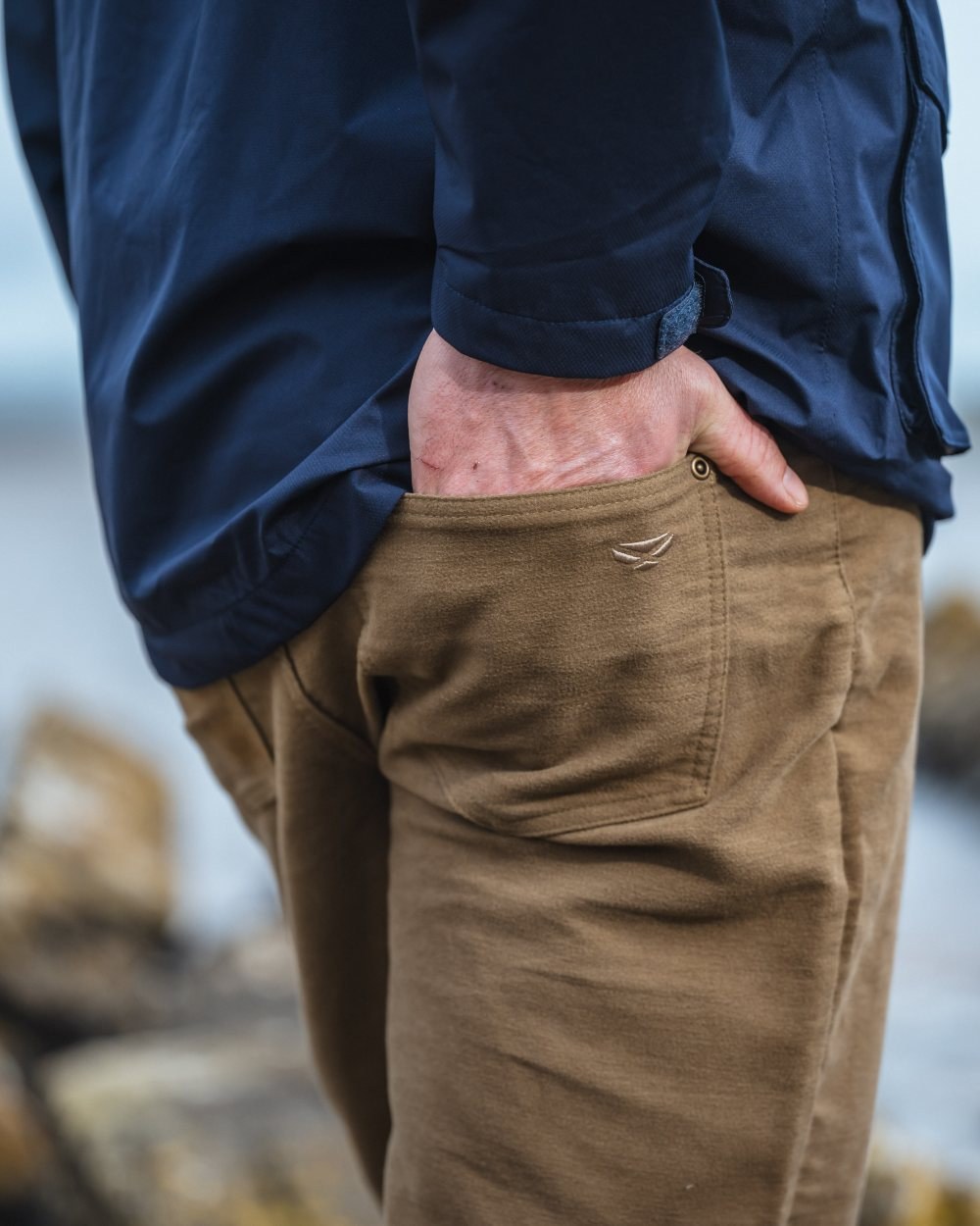 Dried Moss Coloured Hoggs of Fife Carrick Technical Stretch Moleskin Jeans on blurry background 