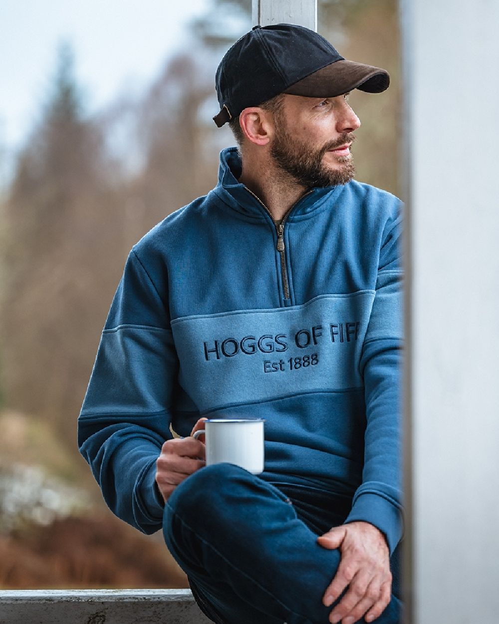 Sea Blue Vintage Blue Coloured Hoggs of Fife Dumfries 1888 Mens Quarter Zip Sweatshirt on blurry background 