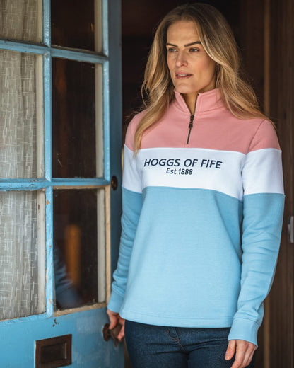 Pink White Blue Coloured Hoggs of Fife Dumfries 1888 Womens Quarter Zip Sweatshirt on door background 