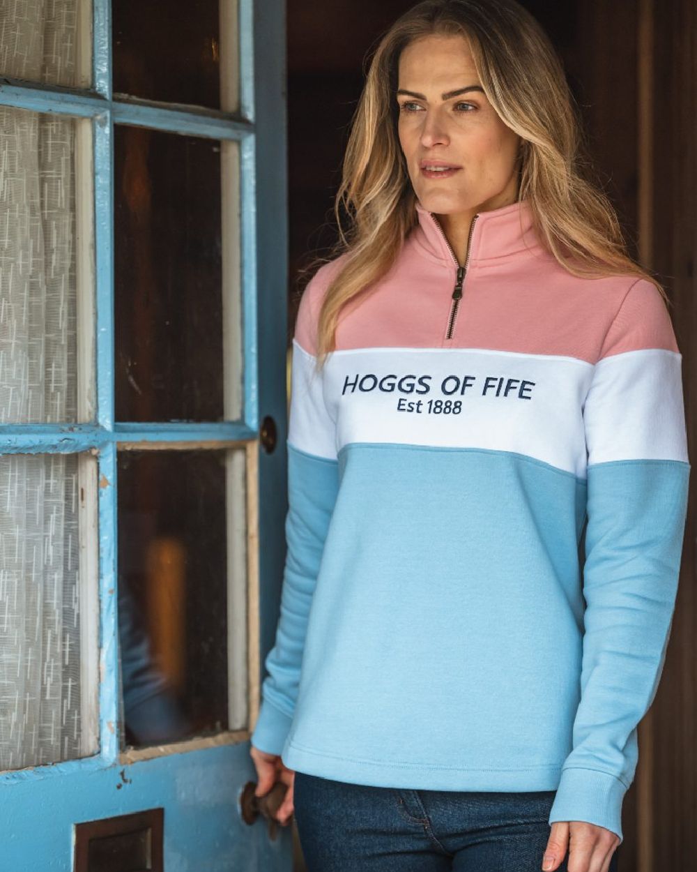 Pink White Blue Coloured Hoggs of Fife Dumfries 1888 Womens Quarter Zip Sweatshirt on door background 