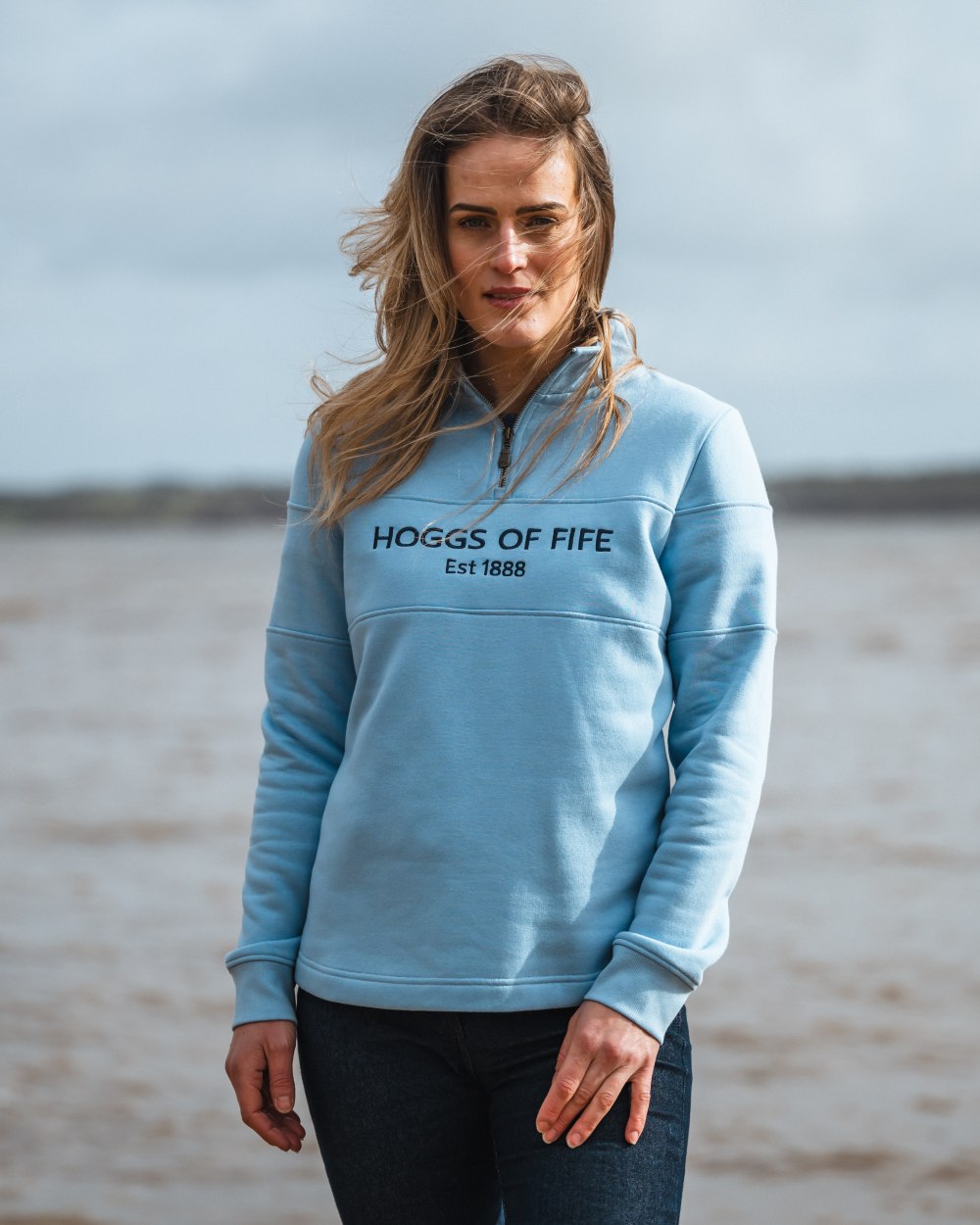 Plain Blue Coloured Hoggs of Fife Dumfries 1888 Womens Quarter Zip Sweatshirt on sea background 