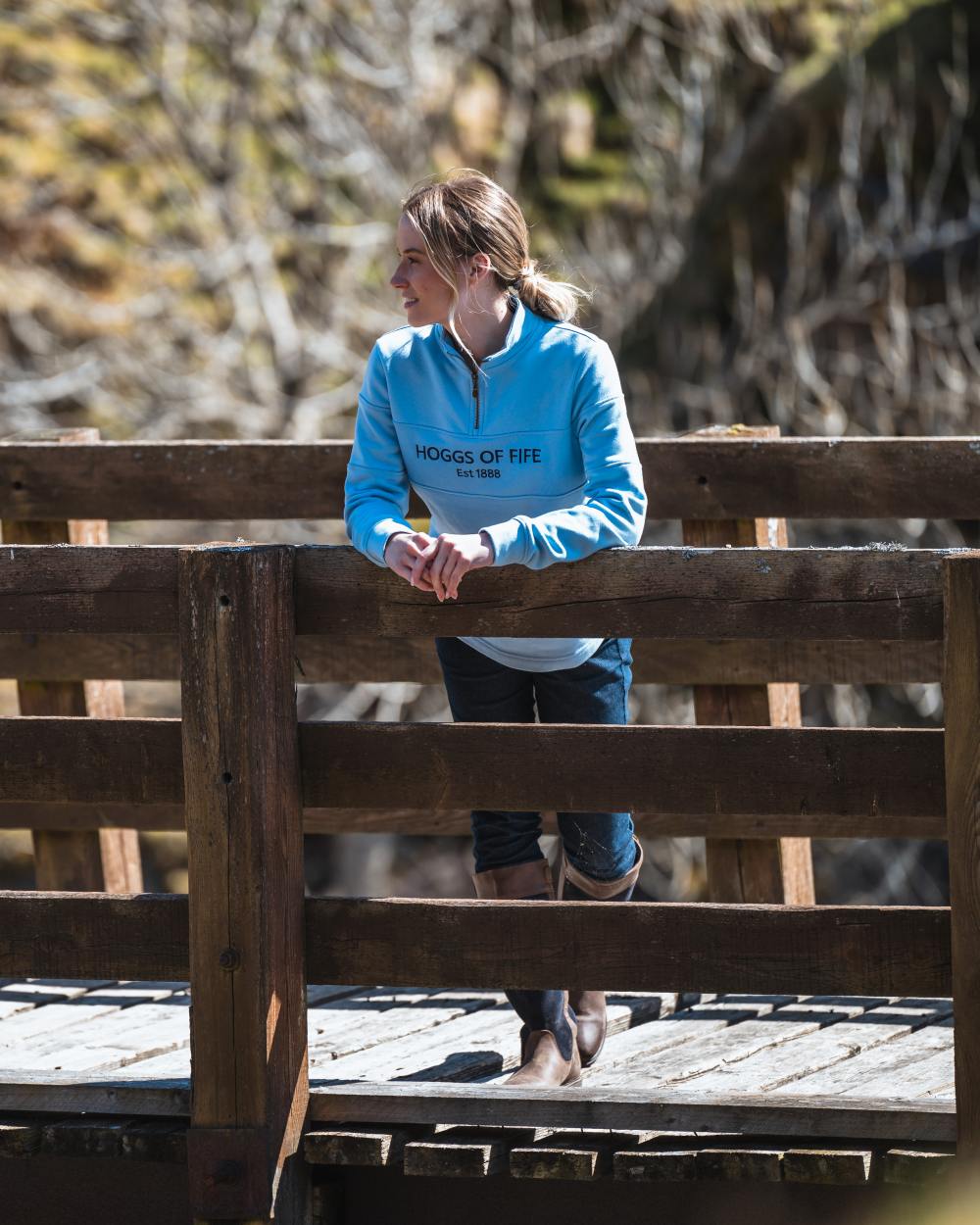 Plain Blue Coloured Hoggs of Fife Dumfries 1888 Womens Quarter Zip Sweatshirt on bridge background 