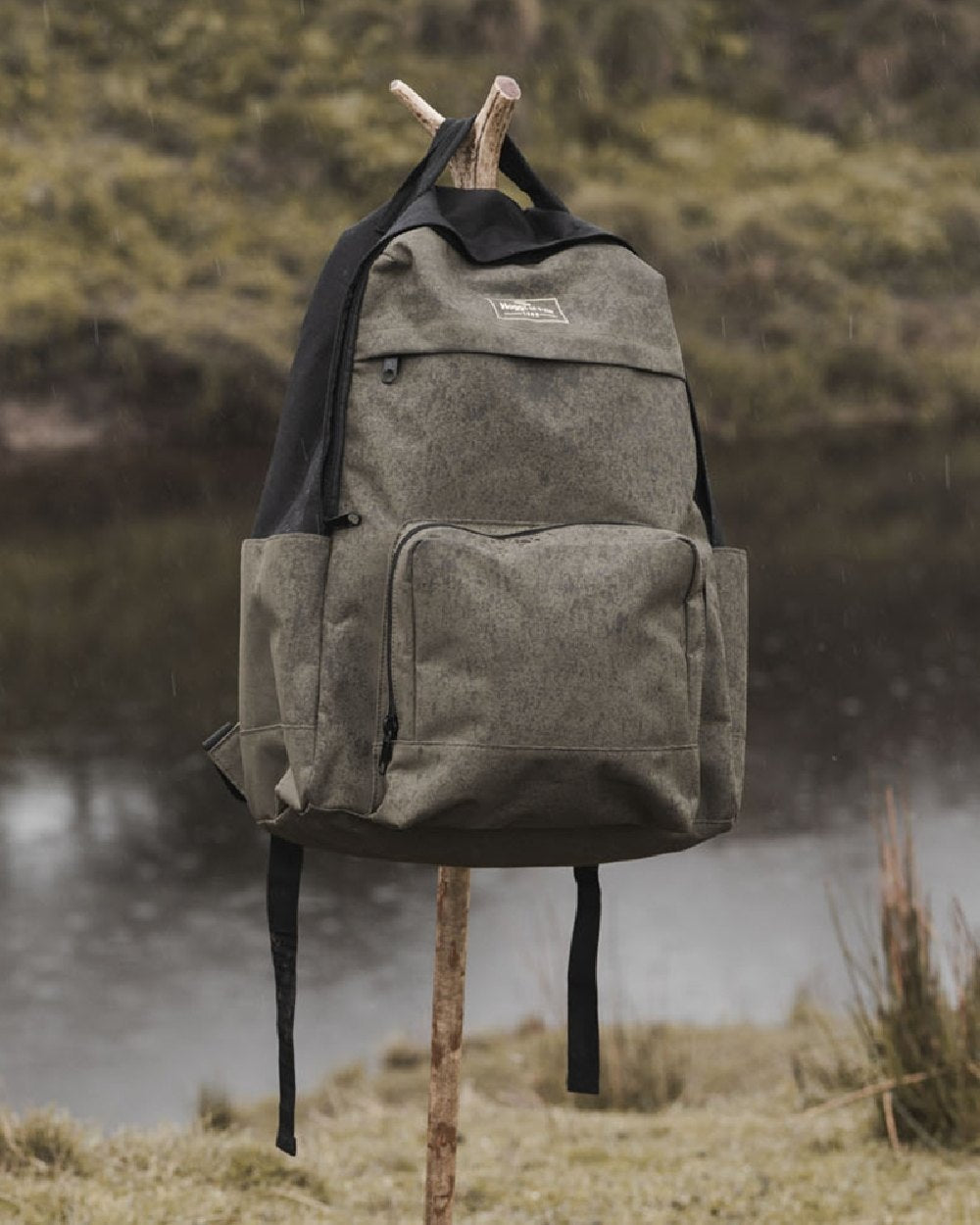 Green Black Coloured Hoggs of Fife Field &amp; Trek Backpack on lake background 