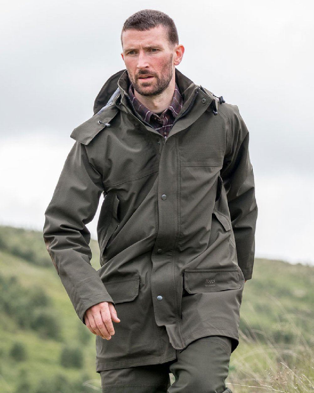 Green Coloured Hoggs of Fife Green King II Waterproof Jacket on blurry background 