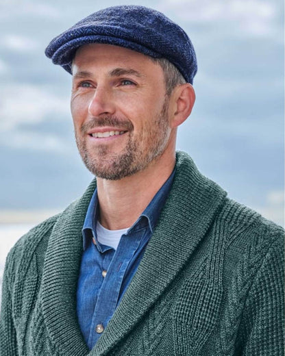 Navy Coloured Hoggs of Fife Herringbone Waterproof Tweed Flat Cap on sky background 