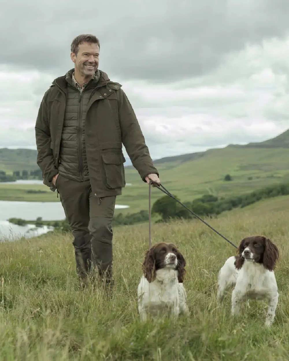 Olive Green Coloured Hoggs of Fife Kincraig Waterproof Field Jacket on countryside background 