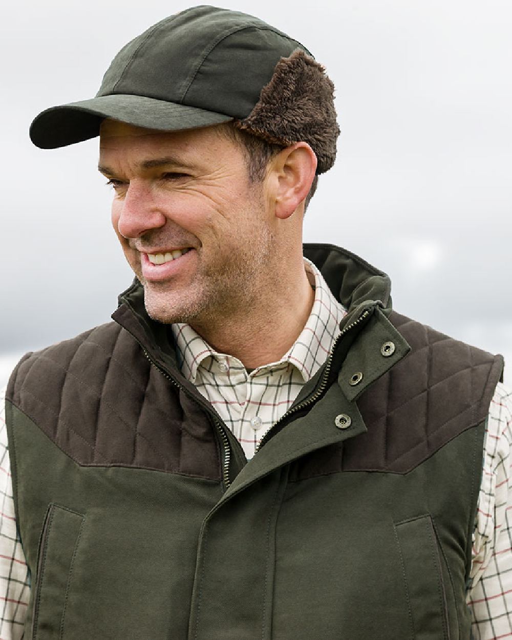 Olive Green Coloured Hoggs of Fife Kincraig Waterproof Hunting Cap on blurry background 