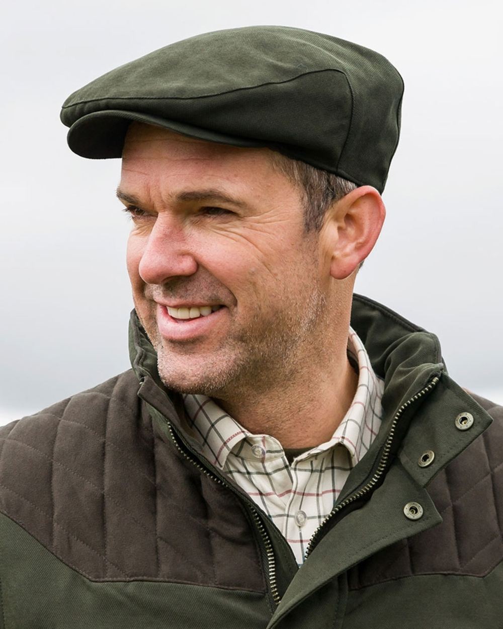 Olive Green Coloured Hoggs of Fife Kincraig Waterproof Tweed Flat Cap on grey background 