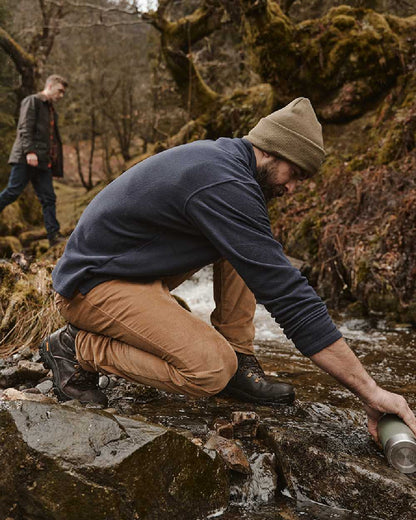 Olive coloured Hoggs of Fife Knitted Thinsulate Waterproof Beanie on mountain background 