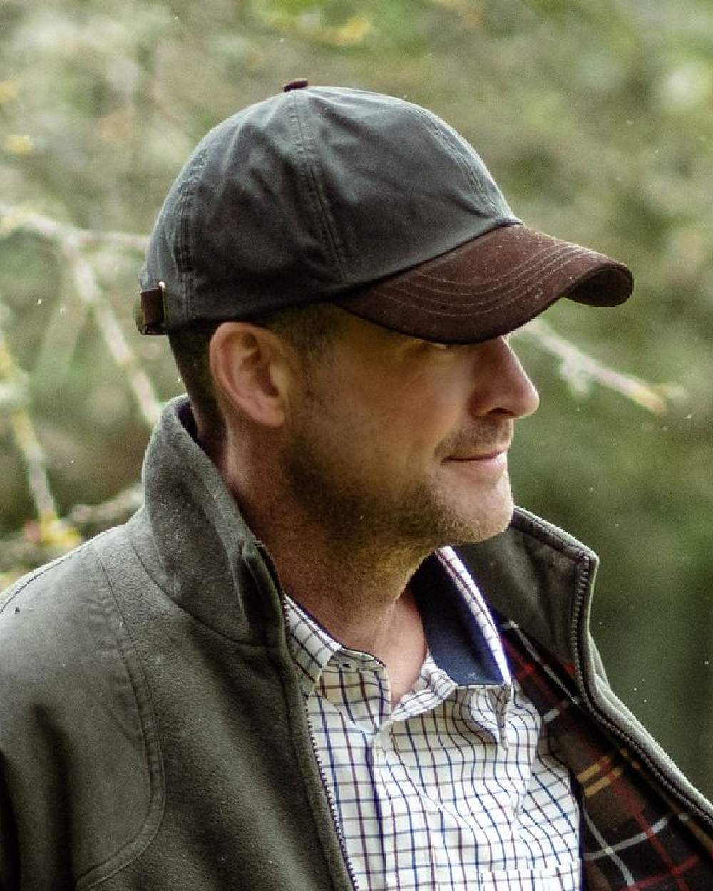 Olive Coloured Hoggs of Fife Leather Peak Waxed Baseball Cap on blurry background 