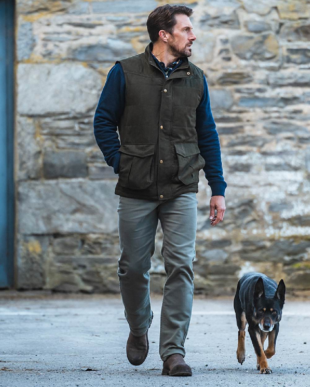 Loden coloured Hoggs of Fife Mens Glenbervie Quilted Gilet on wall background 