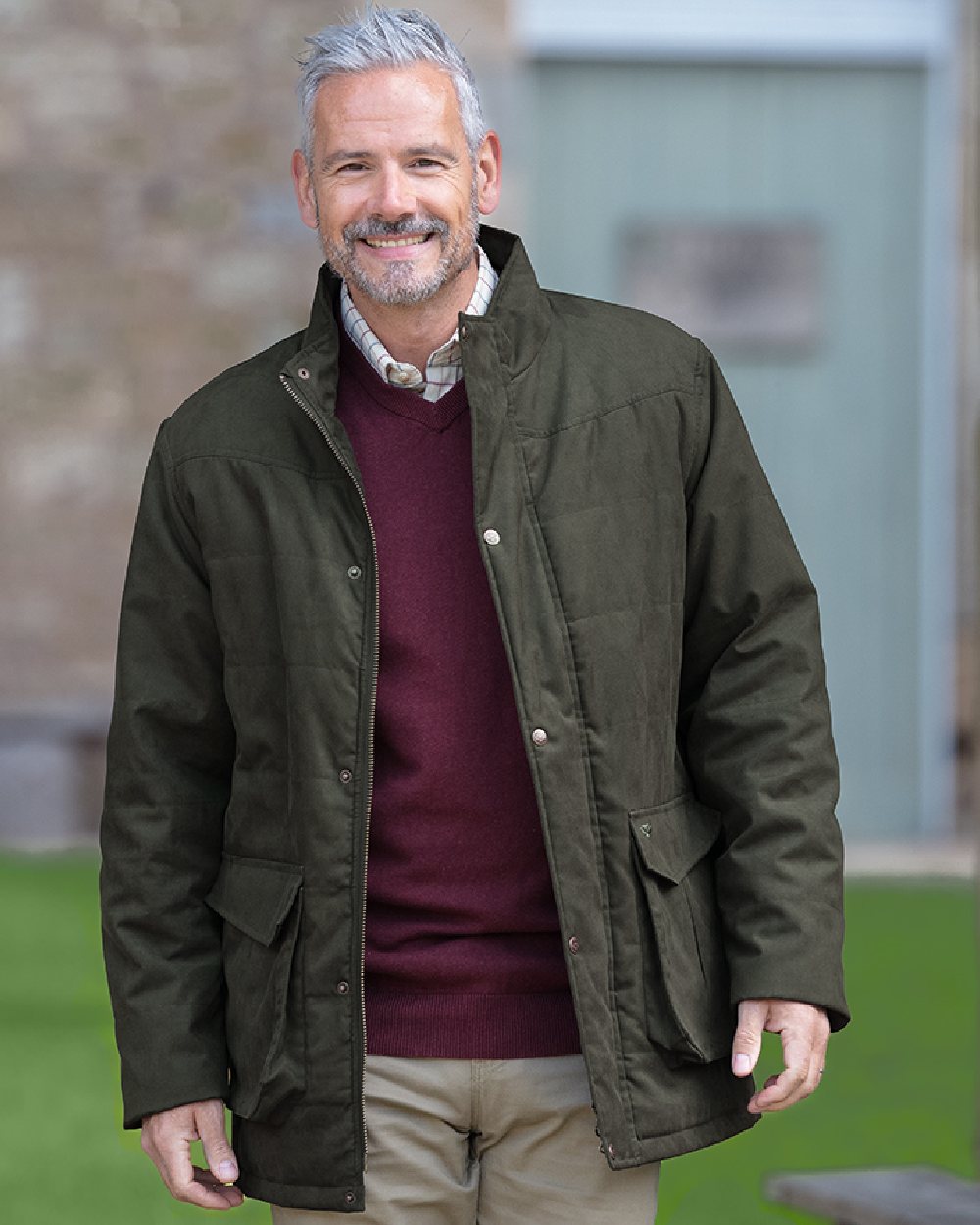 Loden coloured Hoggs of Fife Mens Glenesk Quilted Jacket on blurry background 