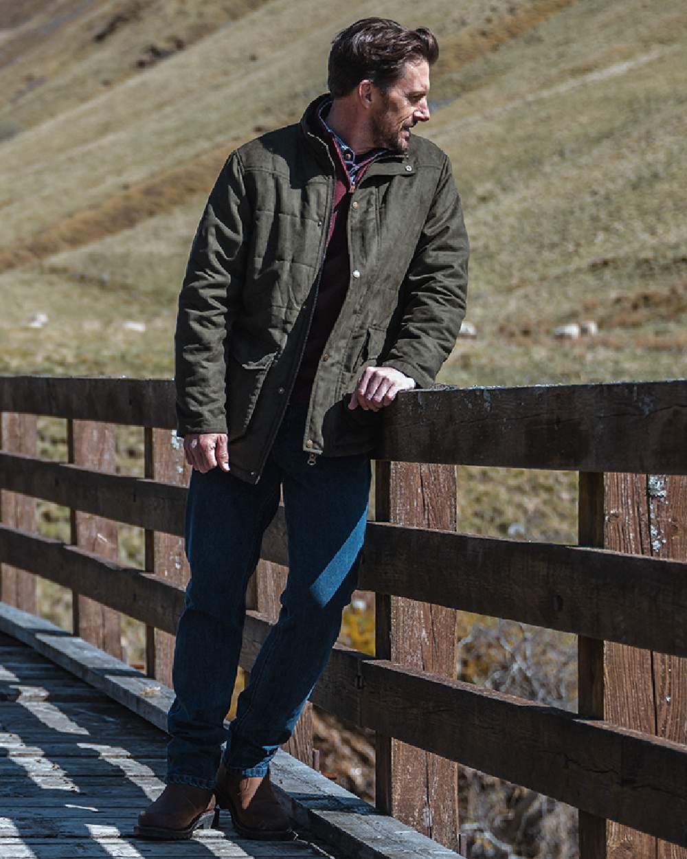 Loden coloured Hoggs of Fife Mens Glenesk Quilted Jacket on blurry background 