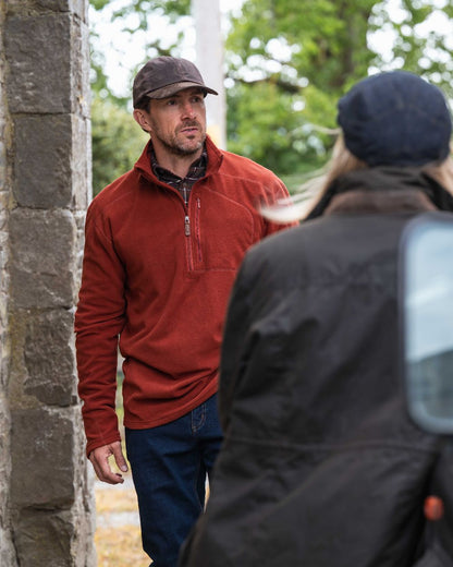 Burnt Henna Coloured Hoggs of Fife Mens Islander Techpro Quarter Zip Shirt on outdoor background 
