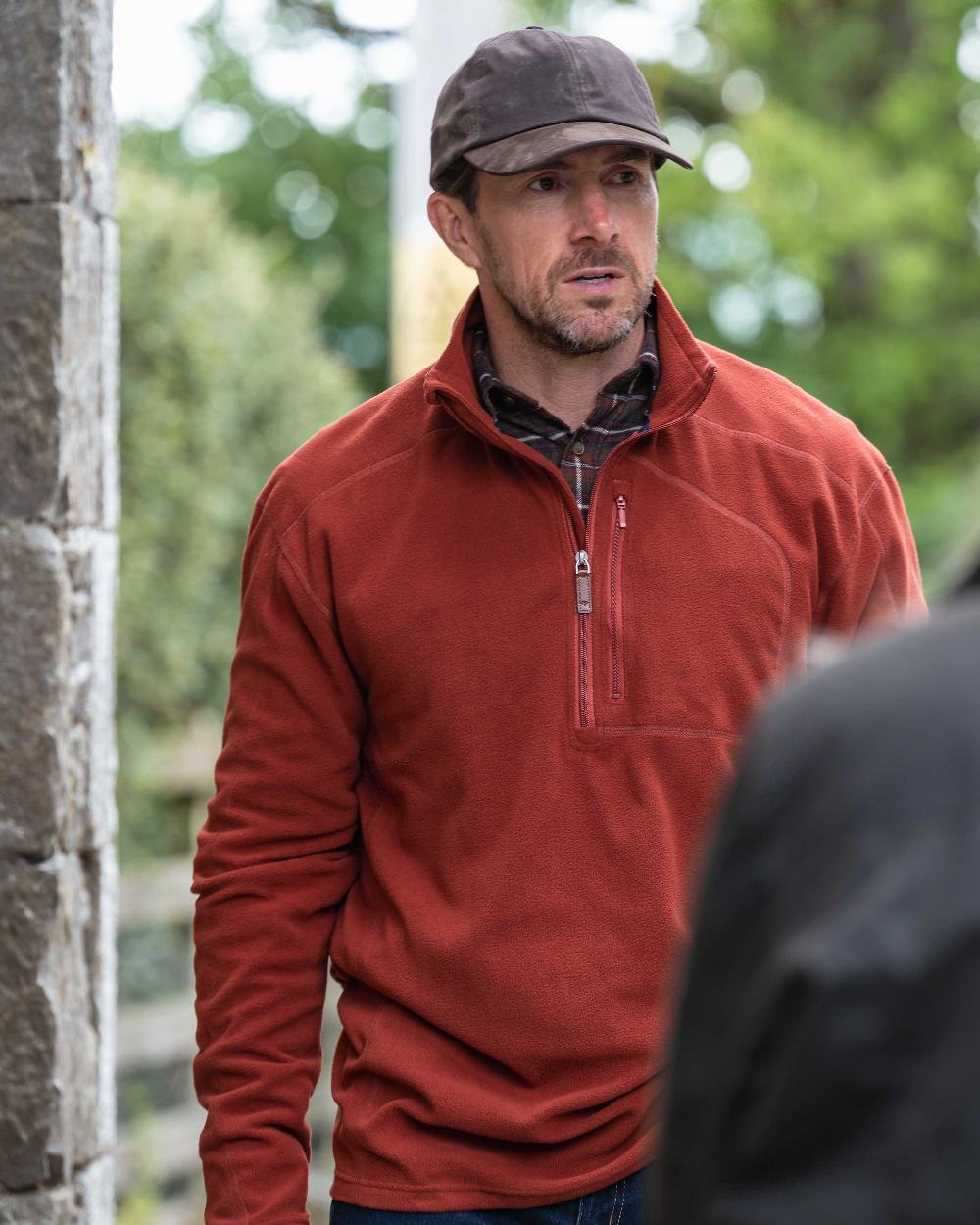 Burnt Henna Coloured Hoggs of Fife Mens Islander Techpro Quarter Zip Shirt on outdoor background 