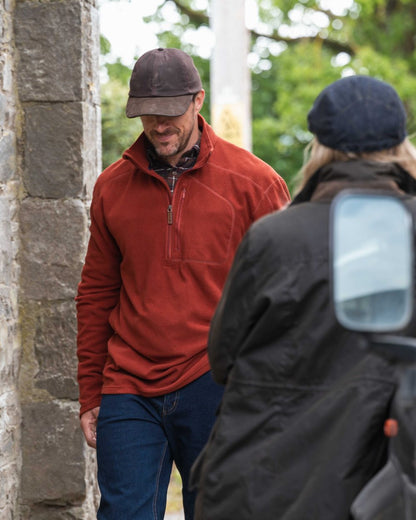 Burnt Henna Coloured Hoggs of Fife Mens Islander Techpro Quarter Zip Shirt on outdoor background 