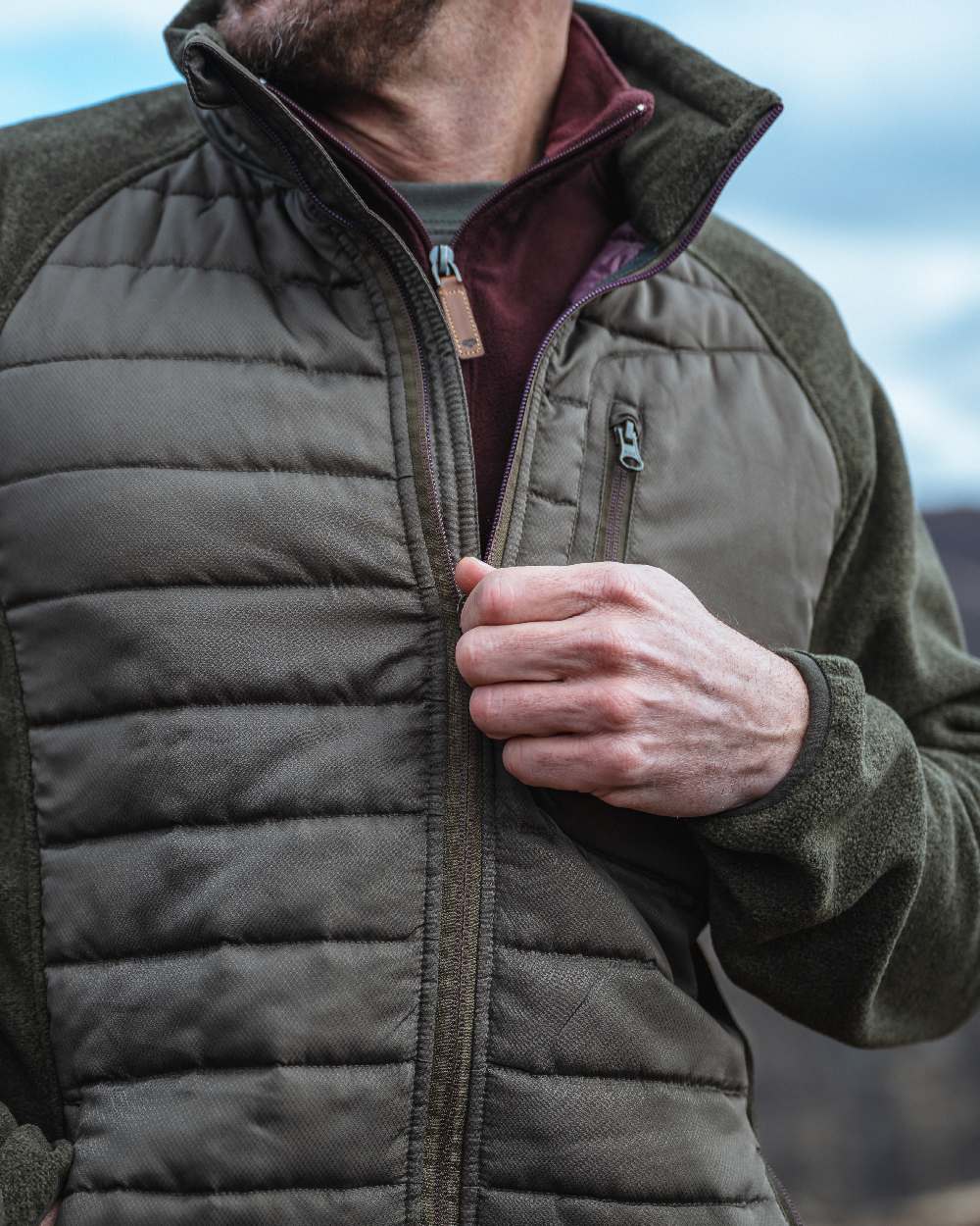 Juniper Marl Coloured Hoggs of Fife Mens Melville Hybrid Jacket on blurry background 