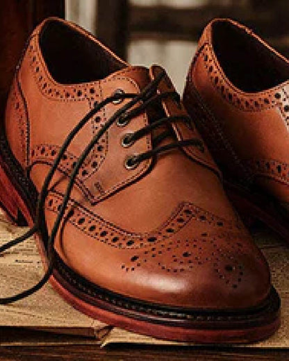 Burnished Tan Coloured Hoggs of Fife Muirfield Brogue Shoe Rubber Soles on wood background 