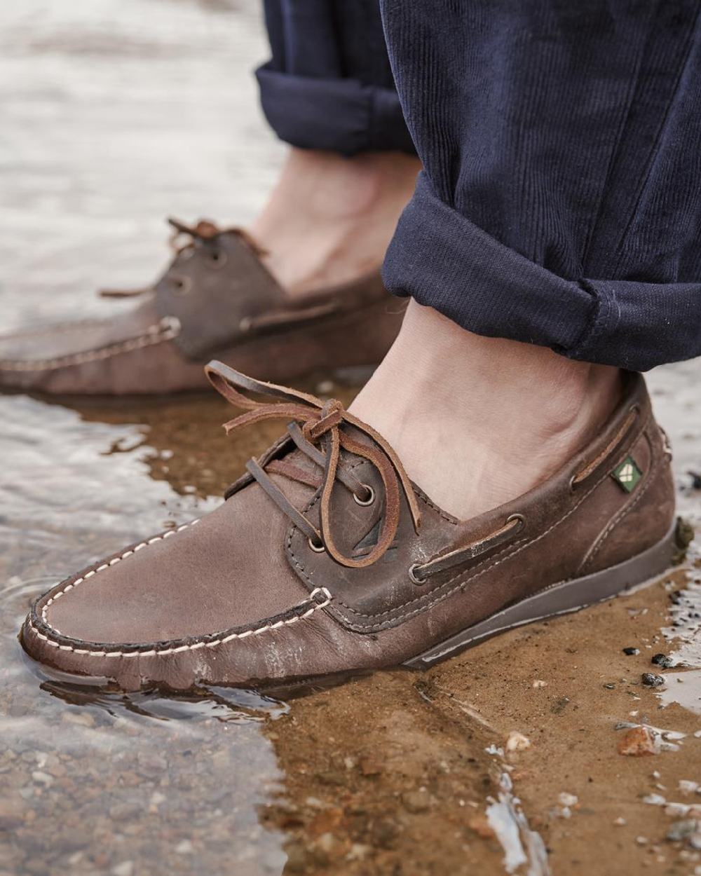 Waxy Brown Coloured Hoggs of Fife Mull Deck Shoes on water background 