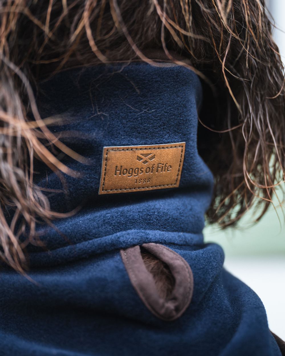 Navy Coloured Hoggs of Fife Stenton Fleece Dog Coat on blurry background 
