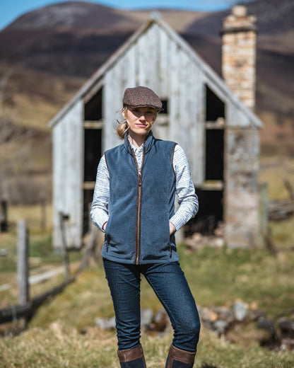 Slate Grey Coloured Hoggs of Fife Stenton Ladies Fleece Gilet on house background 