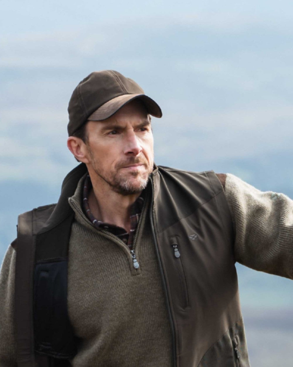 Dark Green coloured Hoggs of Fife Struther Waterproof Baseball Cap on sky background 