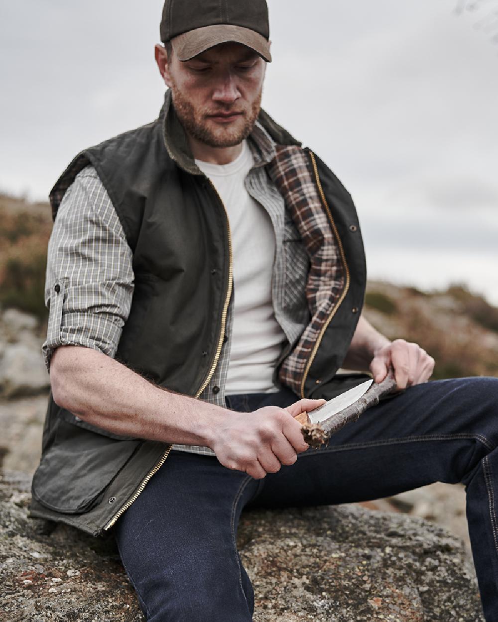 Olive Coloured Hoggs of Fife Waxed Waistcoat on sky background 