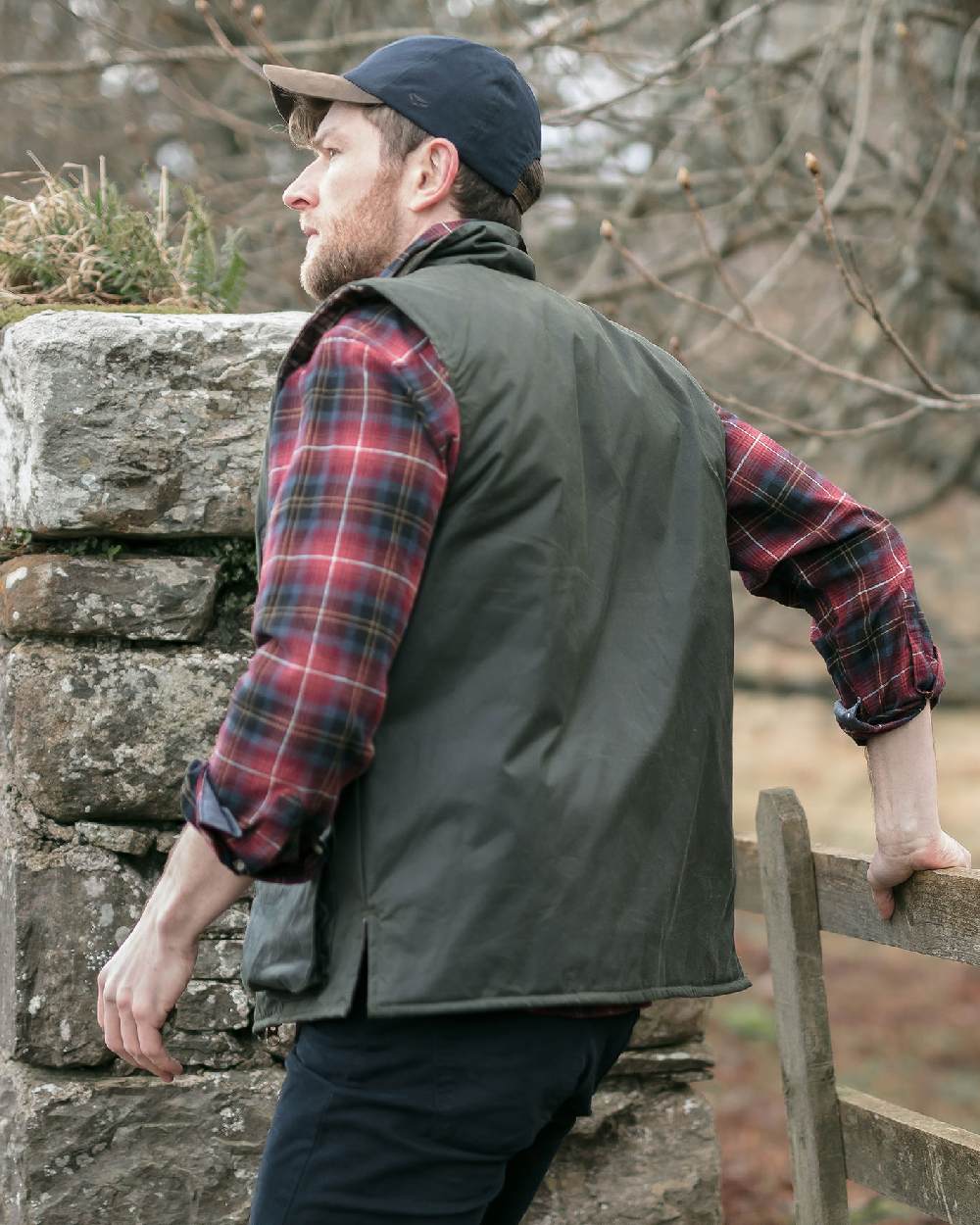 Olive Coloured Hoggs of Fife Waxed Waistcoat on countryside background 