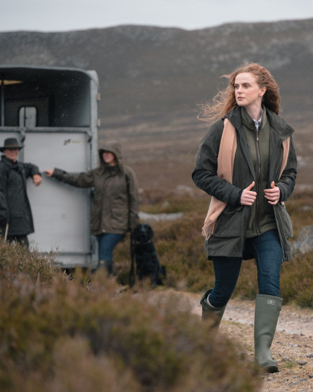 Dark Olive coloured Hoggs of Fife Womens Ardross Pro Waterproof Field Jacket on moorland background 