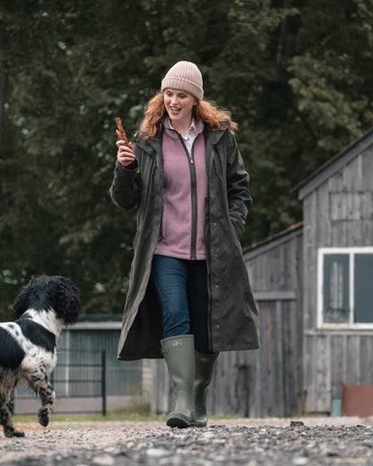 Dark Olive coloured Hoggs of Fife Womens Ardross Pro Long Riding Coat on farm background 