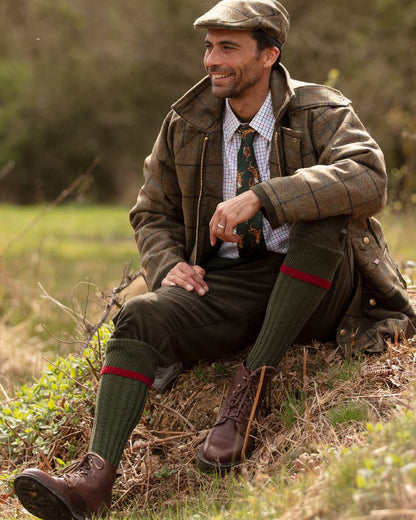 Spruce Brick Red coloured House of Cheviot Estate Field Socks on field background 