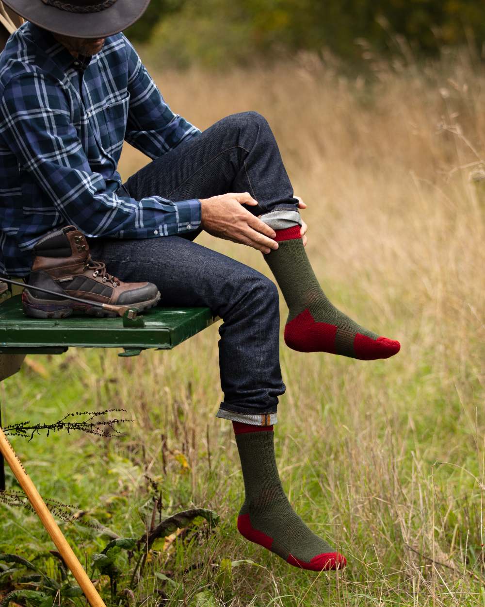 Spruce Brick Red coloured House of Cheviot Glen Technical Socks on field background 