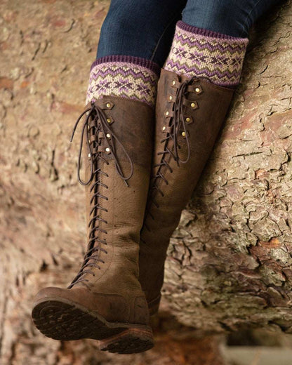 Thistle coloured House of Cheviot Lady Fairsle Socks on stone wall background 