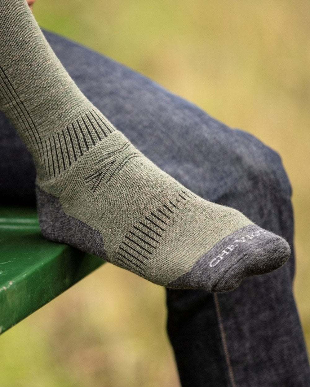 Moss green coloured House of Cheviot Munro Performance Socks on outdoor background 