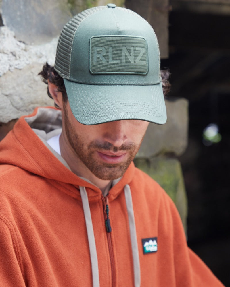 Man wearing a Ridgeline RLNZ trucker cap in olive green outdoors