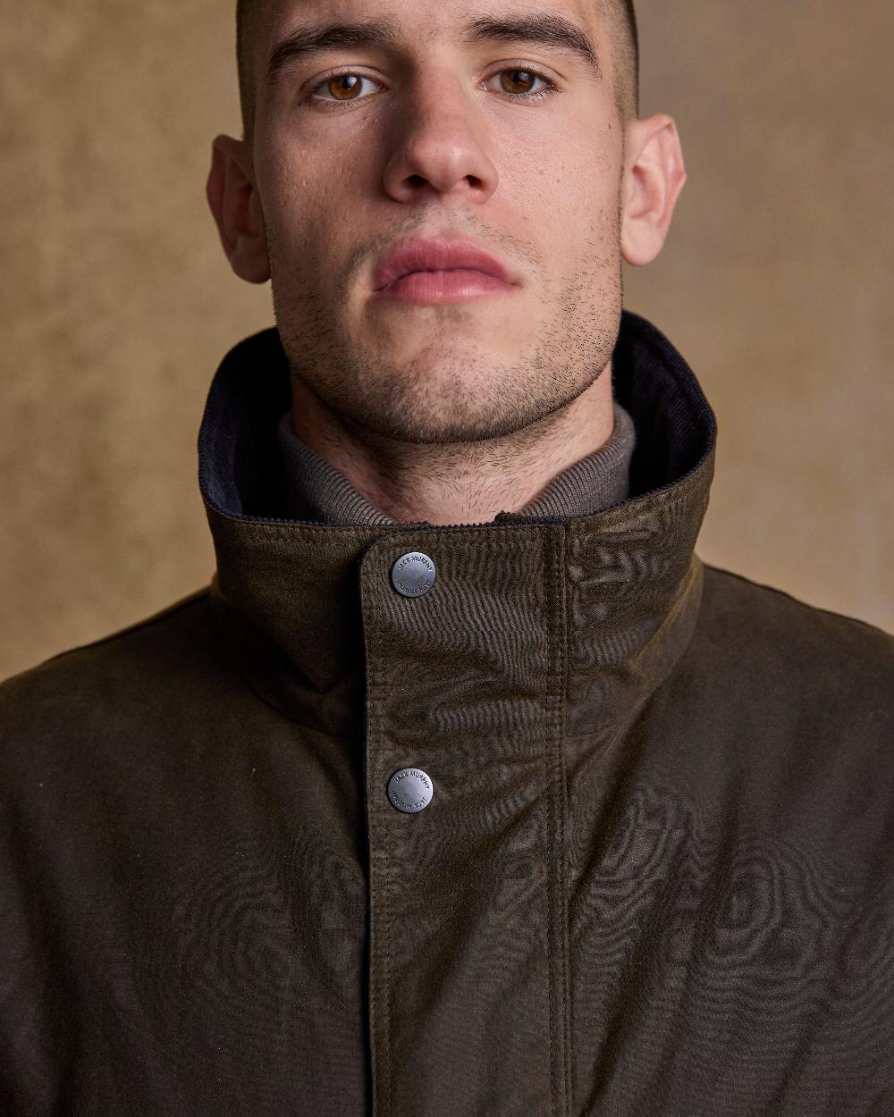 Olive Coloured Jack Murphy Archie Wax Jacket on indoor background 
