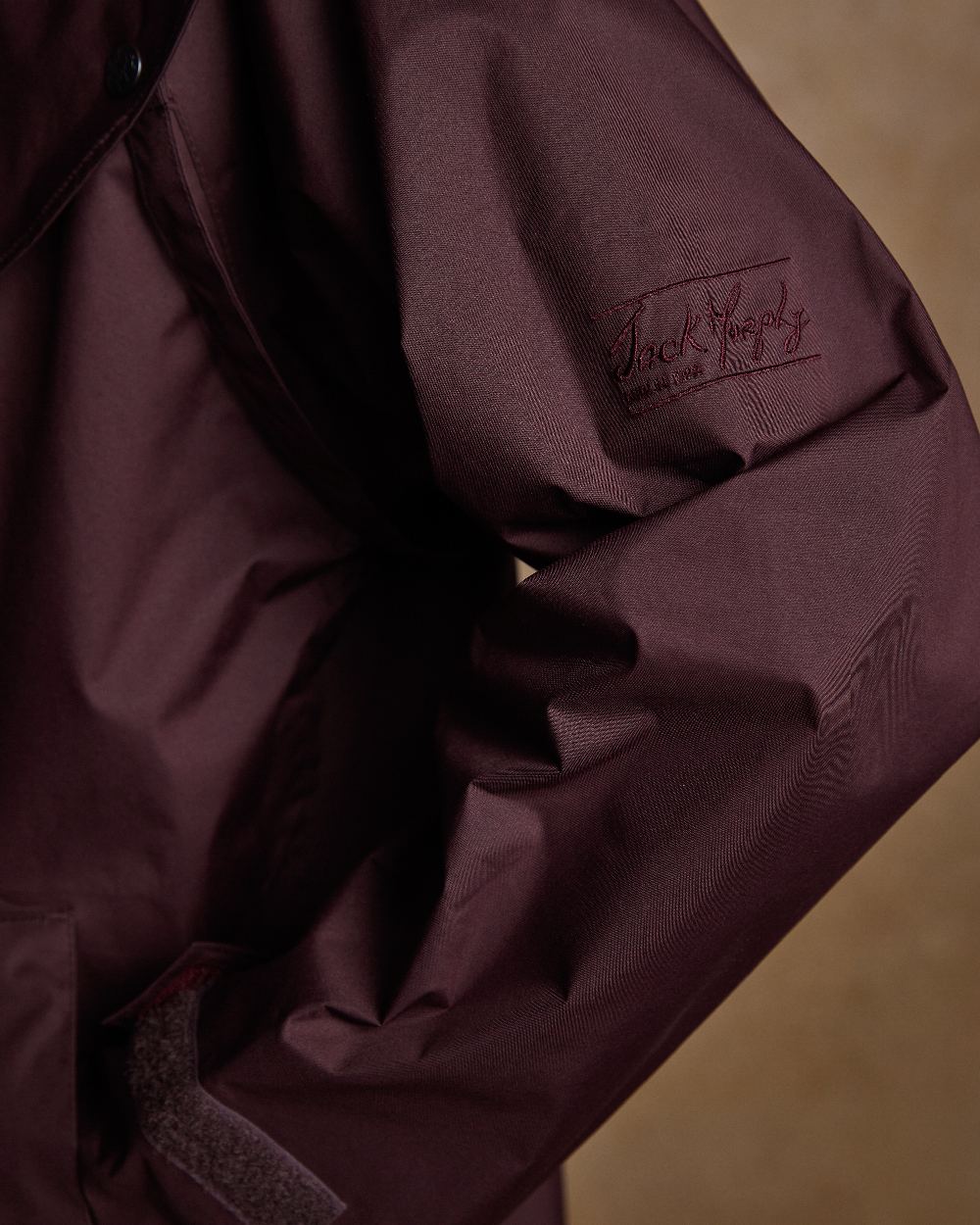 Deep Claret Coloured Jack Murphy Malvern Ladies Waterproof Bush Coat on indoor background 
