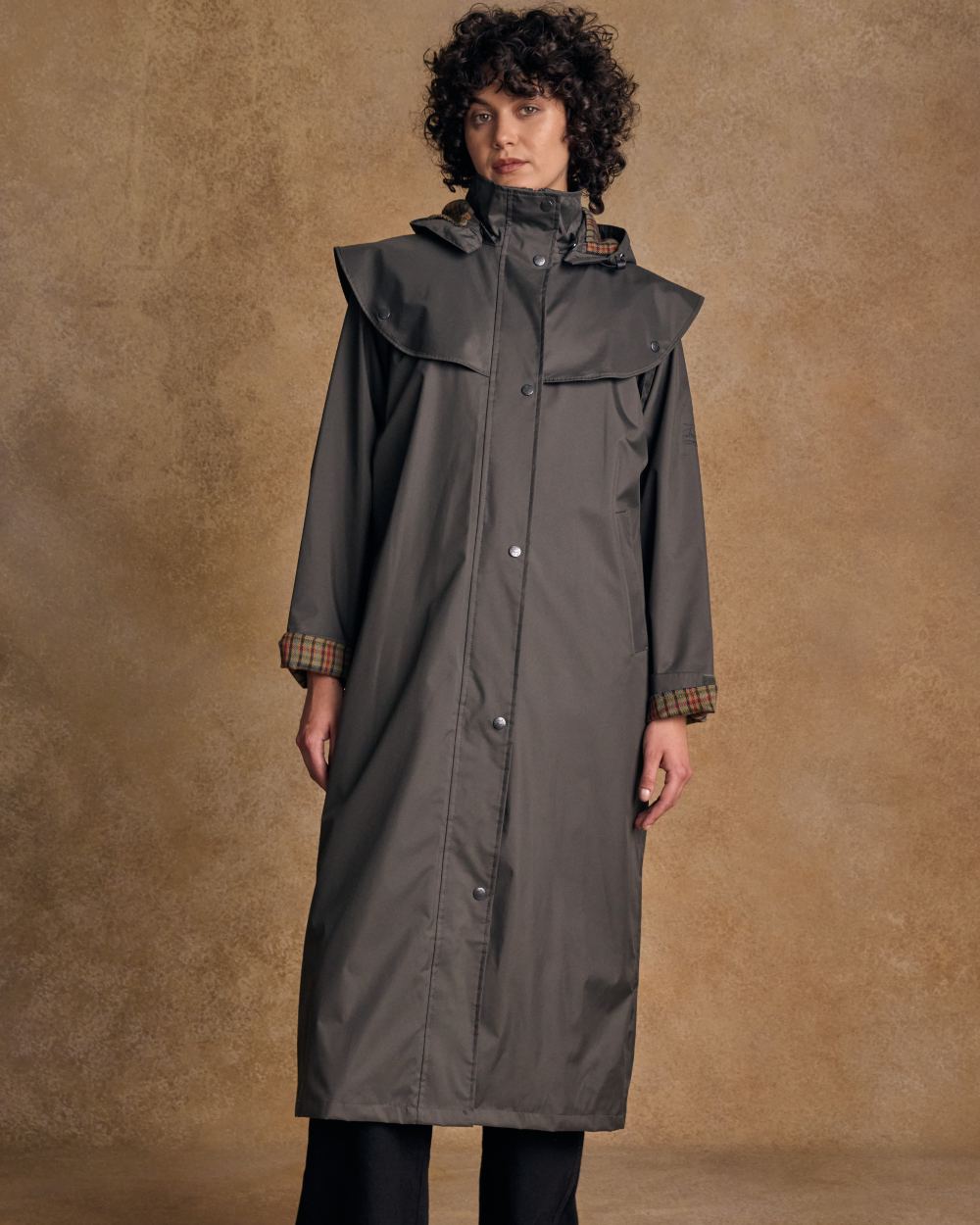 Olive coloured Jack Murphy Malvern Ladies Waterproof Bush Coat on wall background 