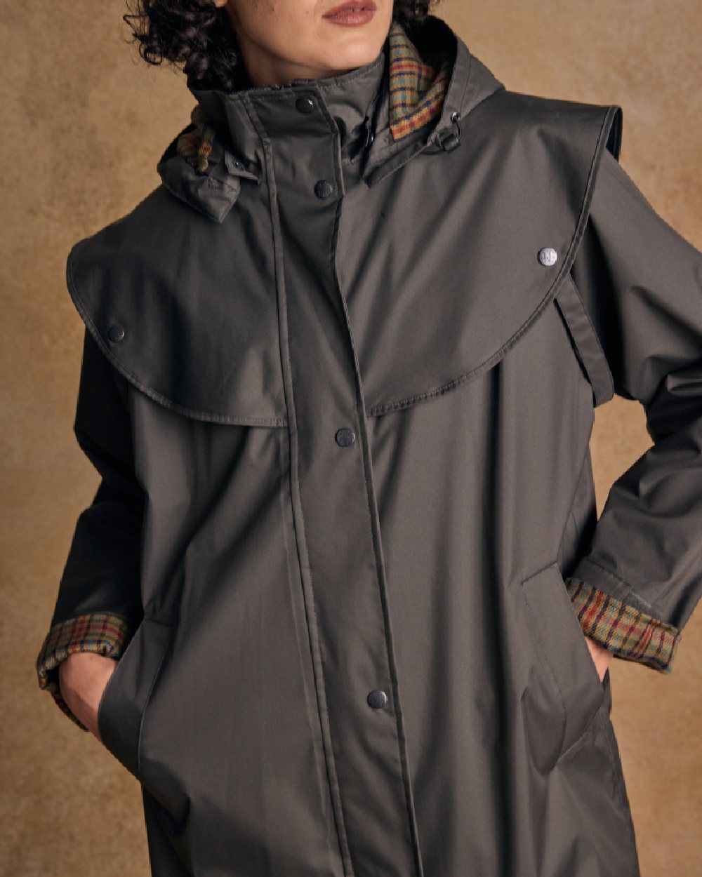 Olive coloured Jack Murphy Malvern Ladies Waterproof Bush Coat on wall background 