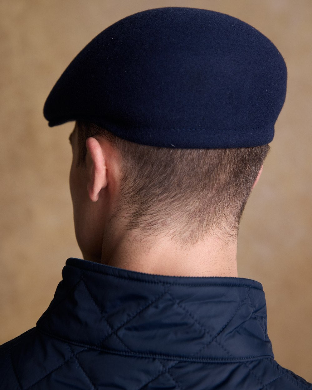 True Navy Coloured Jack Murphy Mens Galway Felt Flat Cap on indoor background 
