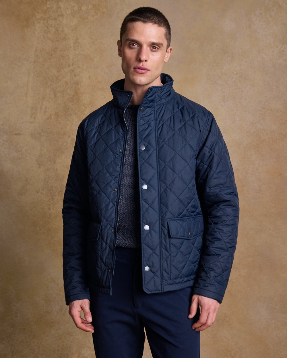 Navy coloured Jack Murphy Ronan Quilted Jacket on wall background 