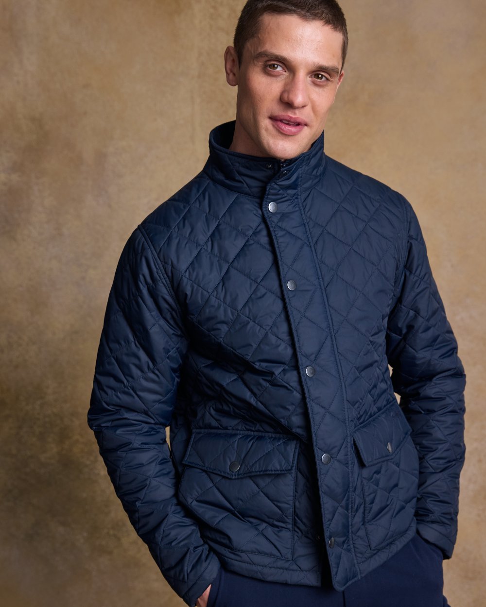 Navy coloured Jack Murphy Ronan Quilted Jacket on wall background 