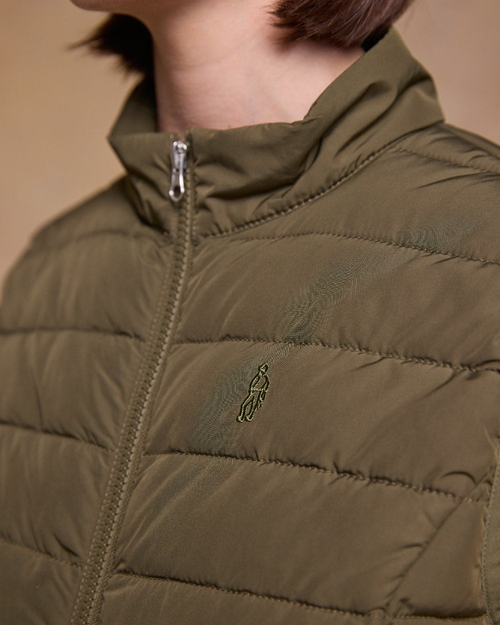Olive Coloured Jack Murphy Womens Leah Puffa Gilet on indoor background 
