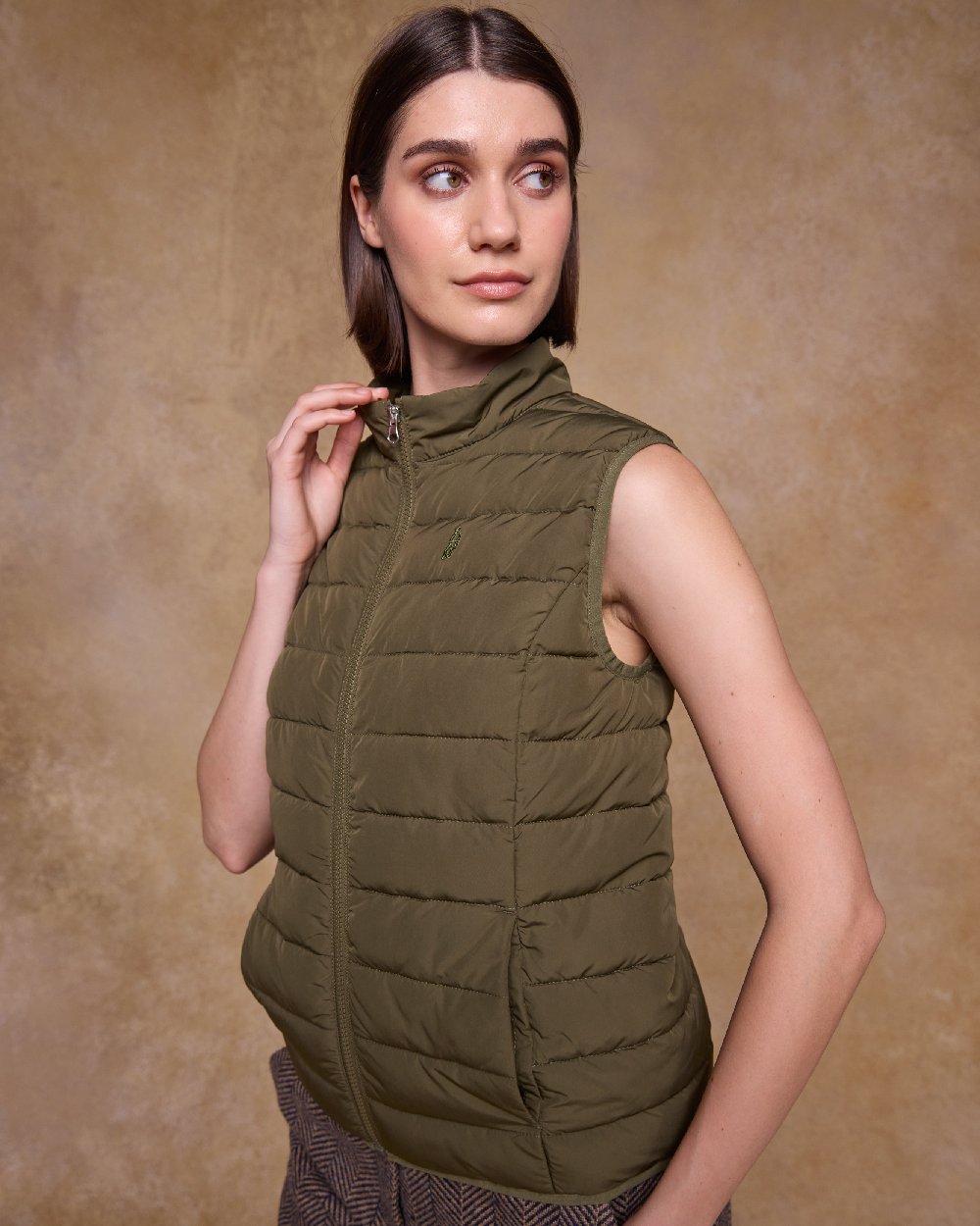 Olive Coloured Jack Murphy Womens Leah Puffa Gilet on indoor background 