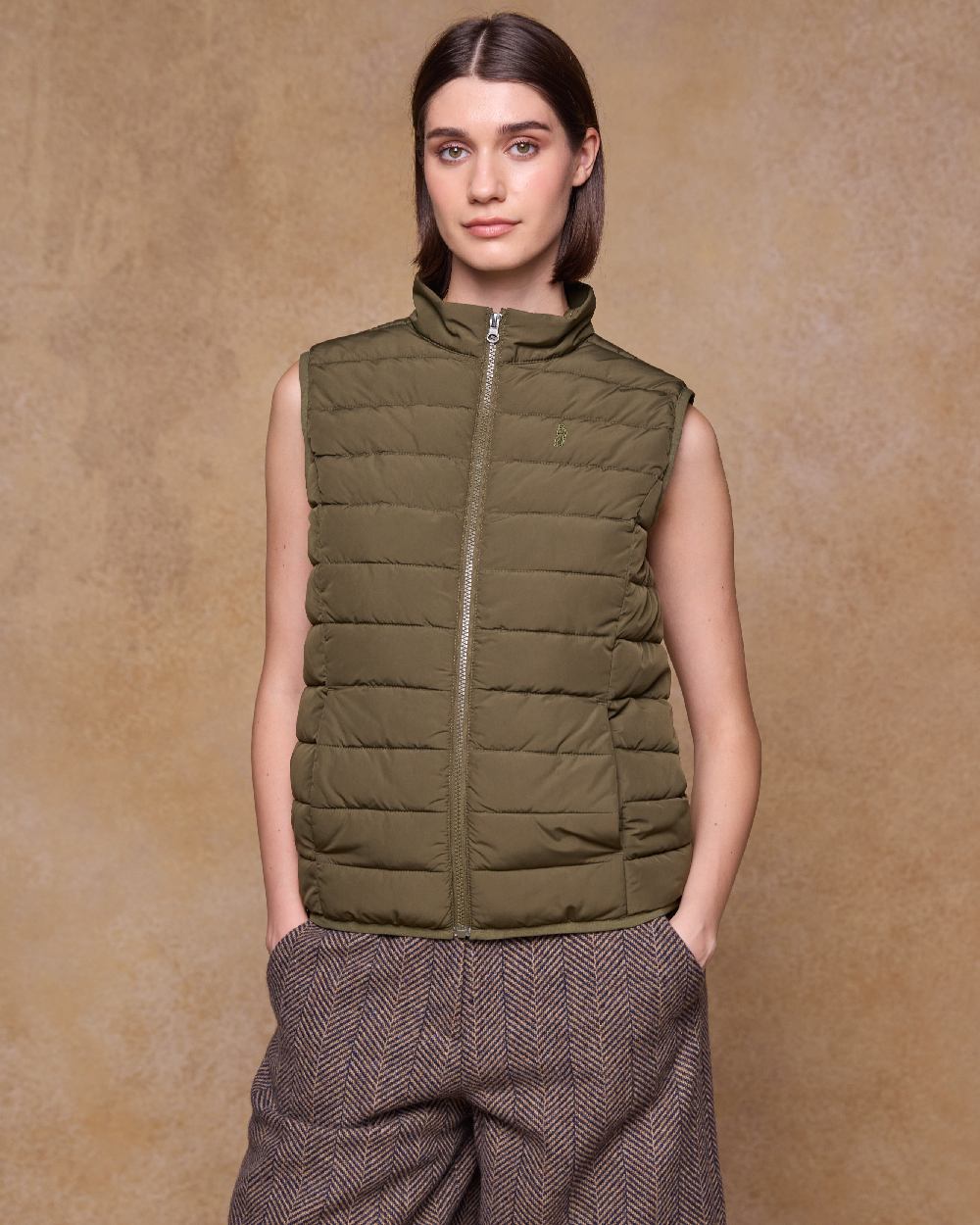 Olive Coloured Jack Murphy Womens Leah Puffa Gilet on indoor background 